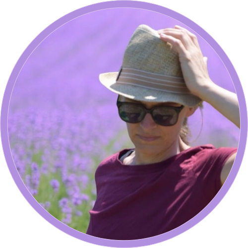 Frau mit Sonnenbrille und Hut vor einem Lavendelfeld